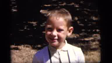 Camden New Jersey (1964): A Brown Haired Boy Smiles While Standing In The Sun Near