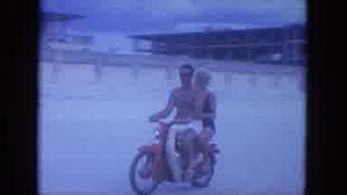 Clearwater Florida (1964): Couple Riding A Motorcycle On A Sandy Beach Passing By