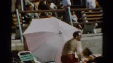 Cleveland Ohio (1964): Man Wearing Red Shorts Brushes Sand From Legs On A Bright