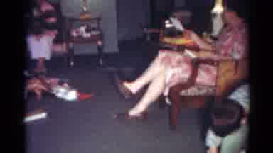 Cleveland Ohio (1964): Children Play With Race Car Set While Woman Wearing Red And