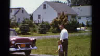 Elkhart Illinois USA (1964): Man Walks Young Boy To A Fifties Model Red Chevrolet