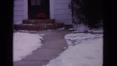 Evanston Illinois (1964): Black Dog Wearing Red Sweater Runs Down Sidewalk On A