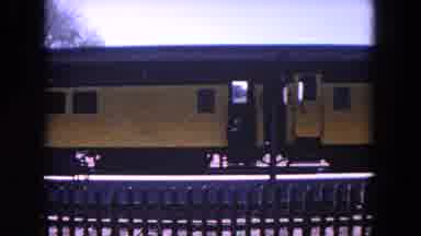 Evanston Illinois (1964): A Person Boarding A Slowly Moving Yellow Train And A Two