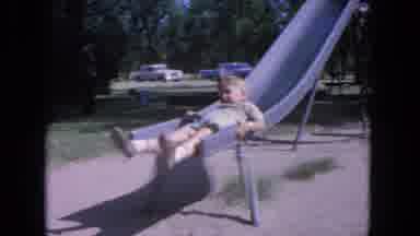 Evanston Illinois (1964): Two Young Boys Slowly Sliding Down A Tall Metal Slide At