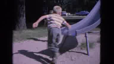 Evanston Illinois (1964): Children Playing On A Slide Outside A Roadside