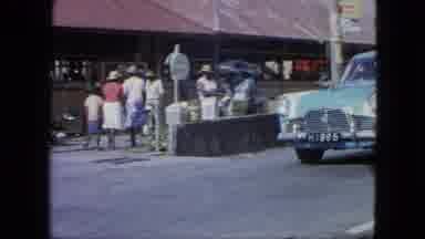 Grenada (1964): Vintage Old-Timer Car Passing Through African Town While Busy