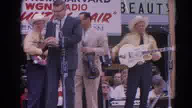 Harvard Illinois USA (1964): Man Making Announcement At A County Fair While Band