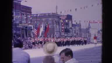 Harvard Illinois USA (1964): Flag Bearers And Band Marching In Parade On A Clear