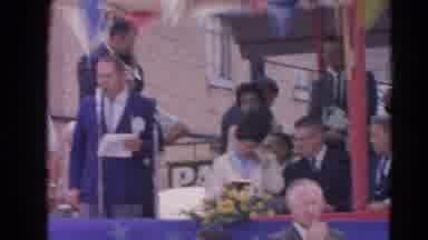 Harvard Illinois USA (1964): Man Speaks To The Crowd As The Parade Marches Through