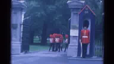 LONDON ENGLAND-1964: Royal Guards March Through Gate While One Stands at Post
