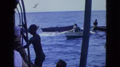Martenique-1964: Row Boat Pulls Up As Others On A Larger Boat Try To Hang On