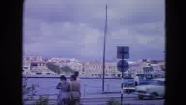Nassau Bahamas-1964: Classic American Cars Drive Along Waterfront Street
