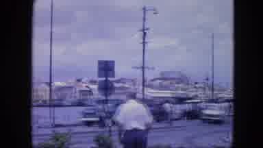 Nassau Bahamas (1964): People Walking At The Shore Of A River In A City