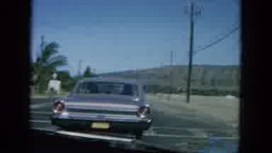 Oahi Hawaii (1964): A Car Driving Down The Road With A Beautiful View Of The Ocean