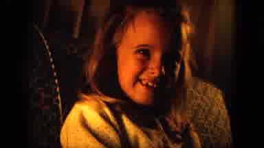 Oahi Hawaii (1964): Girl Wearing White Shirt Sits On Sofa Smiling For The Camera