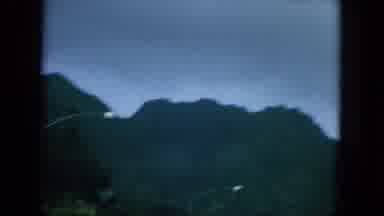 Oahi Hawaii (1964): Flat Road That Passes Beside Wooded And Very High Mountain
