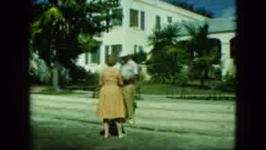Saint Thomas (1964): Well Dressed Man And Woman Stand Outside The Building And