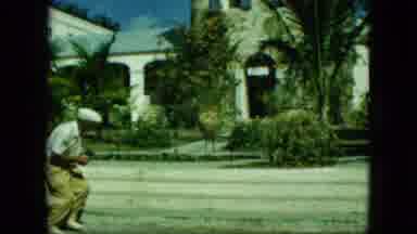 Saint Thomas-1964: Man Walking Near Stone Tower And Tropical Building On A Sunny Day