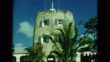 Saint Thomas-1964: Historic Tower with Flags and Palm Trees