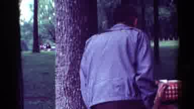 Toledo Ohio (1964): A Kid Walking And A Man Standing Against A Tree With A Jacket