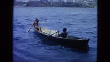 USA Virgin Islands (1964): Two Men Row The Boat In The Water But Don't Seem To Be