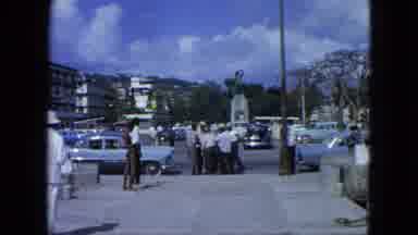 USA Virgin Islands (1964): People And Cars Fill The Parking Lot Outside These Tall