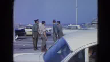 Venezula (1964): Group Of Military Men Talking On Sidewalk By A Ship Dock