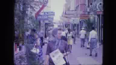 Venezula-1964: Woman With A Foulard Walks Toward The Camera In A Shopping Street