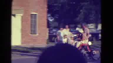 Diller Nebraska (1965): A Tractor Pulls A Float Filled With People Followed By A