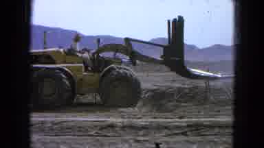 Pueblo Mexico (1965): A Farmer Driving A Big Yellow Tractor Tries To Lift A Pile