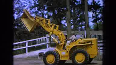 Pueblo Mexico (1965): Subject Driving Heavy Yellow Mannequin In The Garden