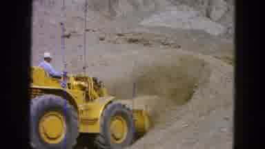 Pueblo Mexico (1965): Person Wearing Blue Shirt Picks Up Sand With Yellow