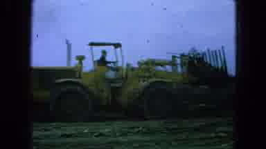Pueblo Mexico (1965): Big Yellow Cat Tractor Driving In A Field On A Sunny Day