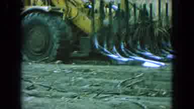 Pueblo Mexico (1965): A Bulldozer Picking Up Plants On A Dirt Plot