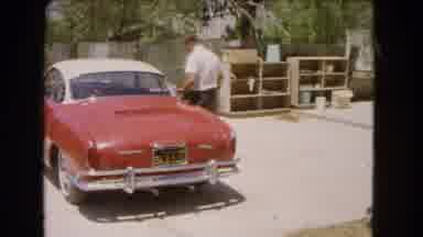 Barstow California USA (1966): Man Closing The Door Of The Big Red Car