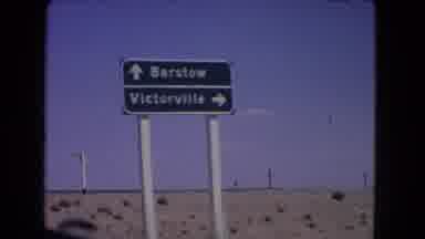 California USA (1966): Film From Vehicle As It Drives Past A Road Sign Giving
