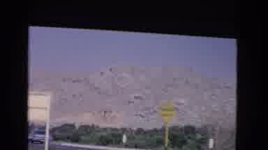 California USA (1966): A Car Parked On A Exit Of A Highway Next To A Mountain