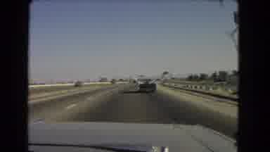 California USA (1966): Car Driving Slowly On Highway During Day Passing Green Sign