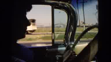 California USA (1966): A Man Probing An Old Car While Looking Outside In Summer