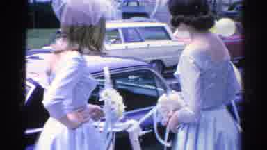 Danville Illinois (1966): Two Bridesmaids Holding Bouquets Stand Besides A Black