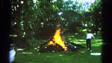 Danville Illinois (1966): A Pile Of Wood Burning Over Grass And A Guy Kicking
