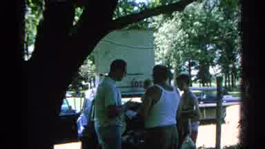 Danville Illinois (1966): A Man In A String Vest Buys Something From A Mans Car