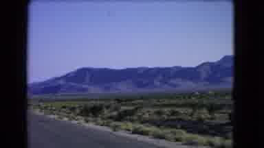 Las Vegas Nevada (1966): A Car Zooms By A Desert And Mountainous Landscape