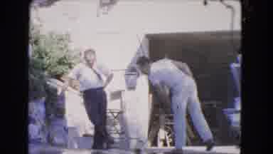 Los Angeles California (1966): Two Men Conversing Outside While One Of Them Sweeps