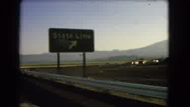 Nevada USA (1966): A Car Driving Past Signs On The Road