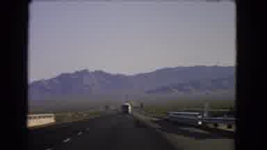 Nevada USA (1966): A Car Steers Toward A Mountain On A Highway