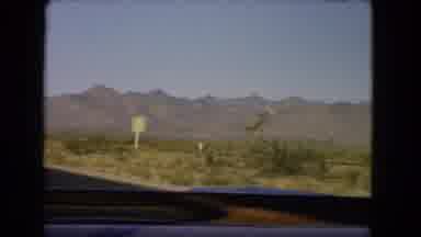 Nevada USA (1966): Truck Driving Through Desert Mountain Range Past Road Signs And