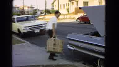 San Pedro California USA (1966): Man Carrying Heavy Object And Putting In The