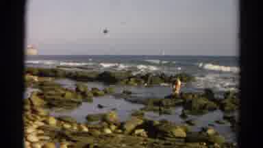 Silver Lake California (1966): A Person Standing On Rocks Near The Ocean