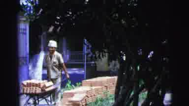 Brazil (1967): A Worker Carries A Pile Of Red Bricks In A Wheelbarrow During A